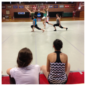 Dancers look on as their peers perform.